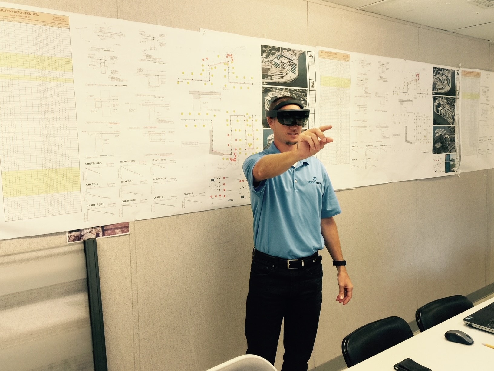 Presenter wearing a VR headset reviewing architectural plans